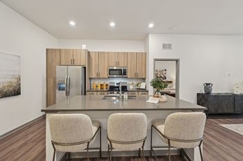 A modern kitchen with a large island and chairs. at The Concord Luxury Apartments, Sarasota